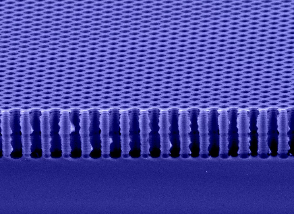 Querschnitt durch ein Phasengitter aus Silizium. Es besteht aus hochpräzise in einem Schachbrettmuster angeordneten zwei Mikrometer grossen Löchern