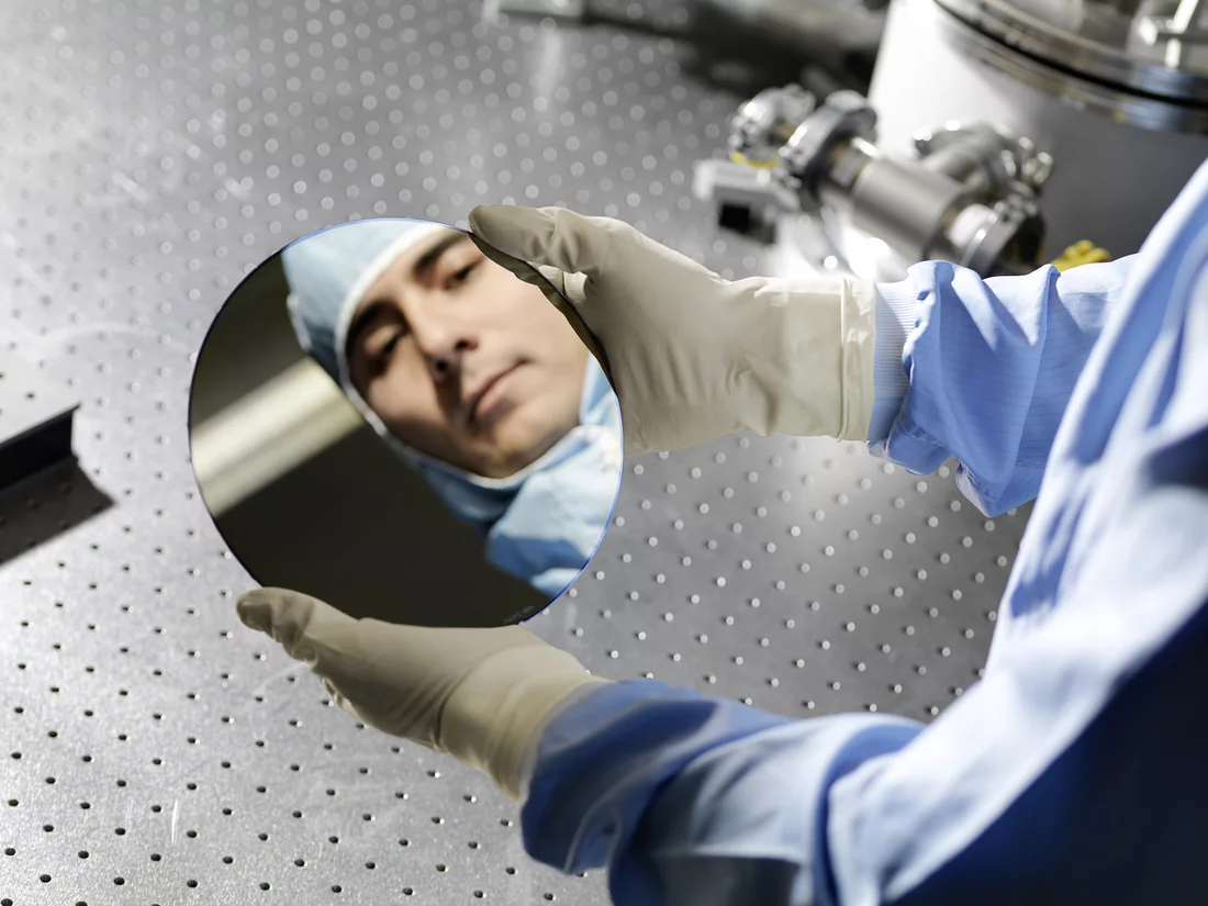 PSI-Forscher Renato Minamisawa mit einem Siliziumwafer, aus dem elektronische Bauteile hergestellt werden können. (Foto: Scanderbeg Sauer Photography)