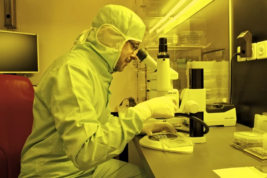 On the light microscope, Helmut Schift checks whether the stamp structures have been moulded evenly during the thermal imprint and whether process changes are necessary. (Photo: Paul Scherrer Institute/Markus Fischer)