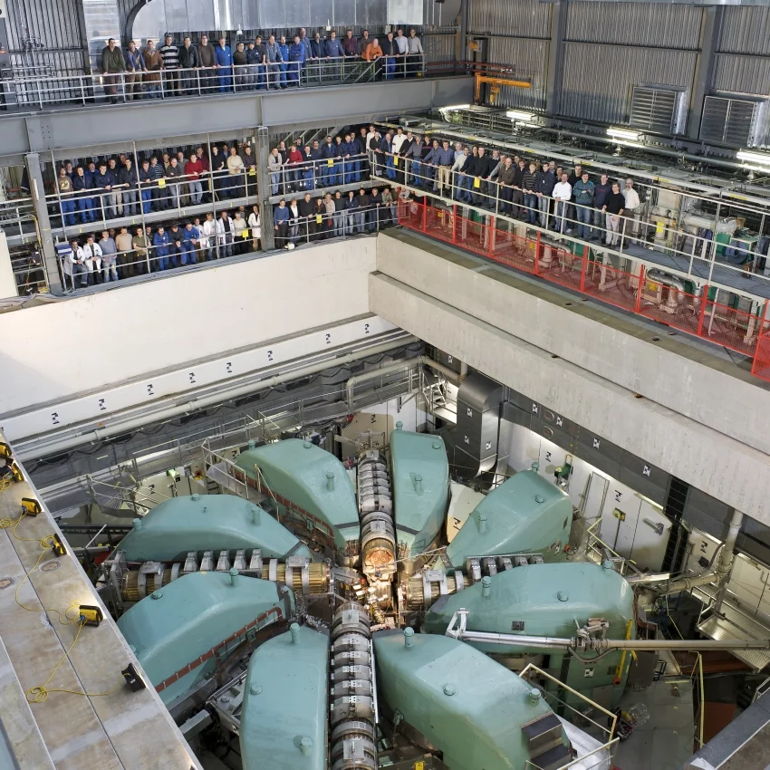 Der grosse Protonenbeschleuniger des PSI. Die Aufnahme ist 2010 entstanden als zuletzt die Dachabschirmung komplett entfernt worden war. Auf der Galerie sind Mitarbeitende aus dem Umfeld der Anlage zu sehen. (Foto: Paul Scherrer Institut/Markus Fischer)