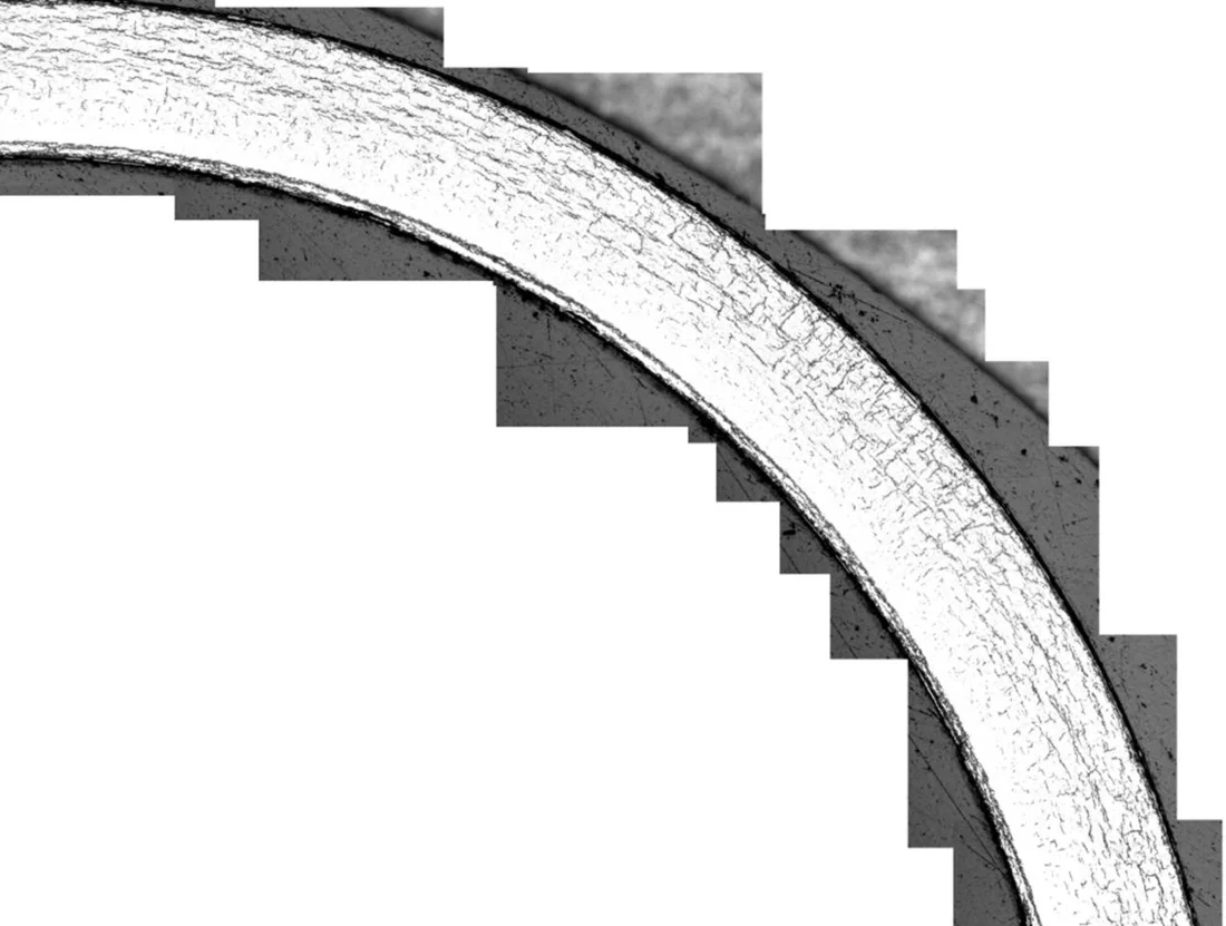 Illustration of the hydrides in the cladding tube. The hydrides are visible as dark thin lines on the light background (interior of the cladding tube). Most hydrides are oriented along the circumference of the cladding tube, but some transverse thereto, i.e. in the radial direction. Picture: Paul Scherrer Institute.