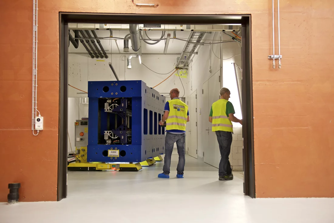 Das Undulator-Gestell wird mit einem speziellen Luftkissenfahrzeug in die Montagehalle navigiert. Etwa zwei Stunden dauert der rund 50 Meter weite Transport. Foto: Markus Fischer/PSI