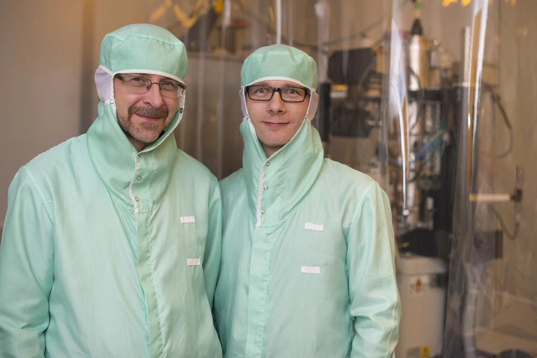 Die PSI-Forscher Helmut Schift und Robert Kirchner in einem Reinraumlabor am Paul Scherrer Institut. Sie müssen hier spezielle Schutzanzüge tragen, damit kein Staub aus der Kleidung auf die zum Teil nur einige Nanometer grossen Strukturen gerät, mit denen hier gearbeitet wird. (Foto: Paul Scherrer Institut/Mahir Dzambegovic)