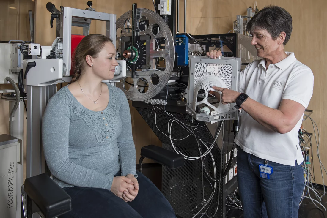 At the treatment station OPTIS 2, two radiation therapists show how the irradiation works: Eline ter Heijden presents the positioning of the patient, and Heidemarie Wagner uses a model to explain the use of the mask and bite block. (Photo: Paul Scherrer Institute/Mahir Dzambegovic)