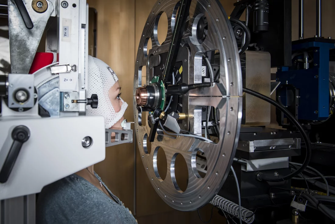 The patient’s position directly in front of the proton beam outlet at the OPTIS 2 device. To ensure that the beam hits the tumour with 100-percent accuracy, the patient´s head must remain immobilised during treatment by means of a mask and bite block. (Photo: Paul Scherrer Institute/Mahir Dzambegovic)