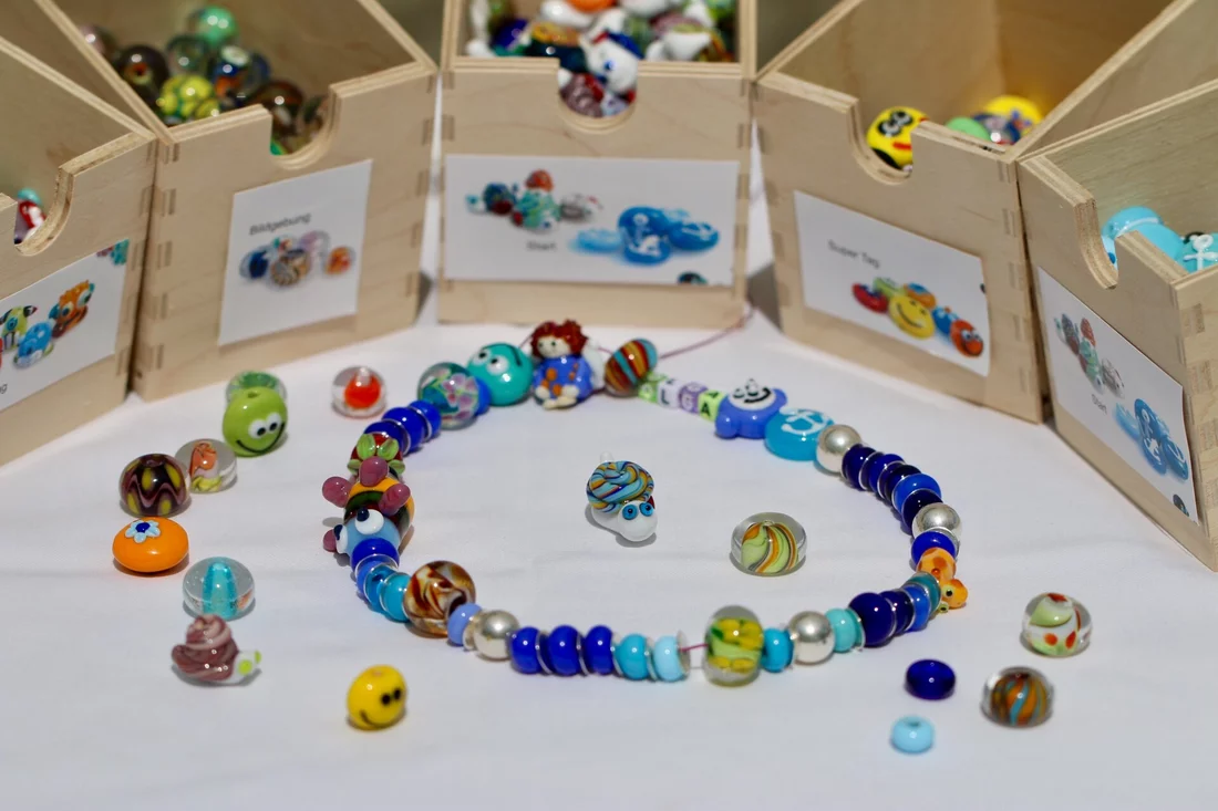 During proton treatment, every child is rewarded with a gift: a necklace of glass beads bearing the child's name. The necklace grows as treatment progresses, with a new hand-made bead added for every irradiation session or medical examination. (Photo: Paul Scherrer Institute/Manuela Reisinger)