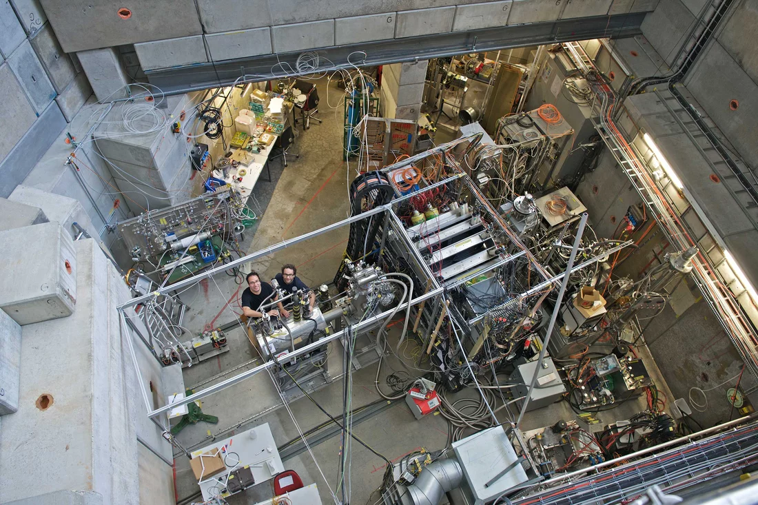 Aldo Antognini et Karsten Schuhmann dans la halle d'expérimentation de l'Institut Paul Scherrer. (Photo : Institut Paul Scherrer/Markus Fischer)