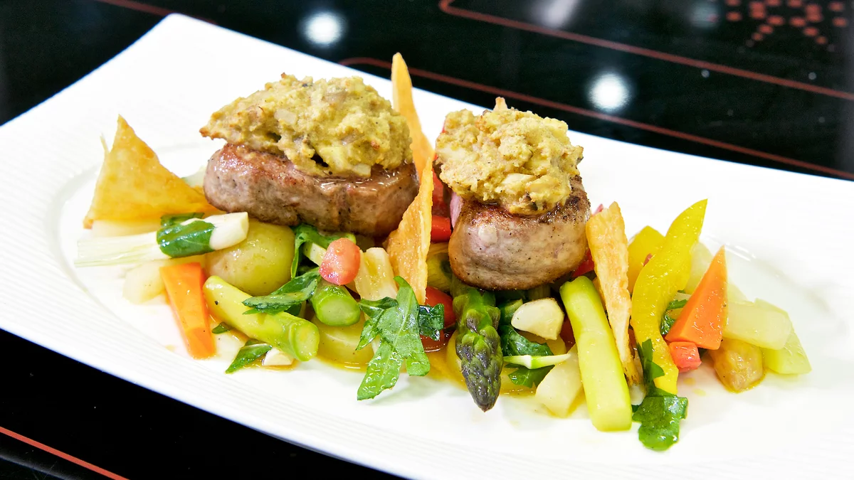 Schweinsfiletmedaillons mit Pilz-Senfhaube auf lauwarmem Gemüsesalat an Tomaten-Rucola-Vinaigrette