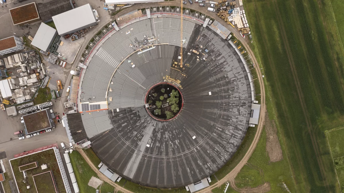 Aerial view of the round building of the Swiss Light Source SLS from spring 2024. One third of the old roof has already been removed.