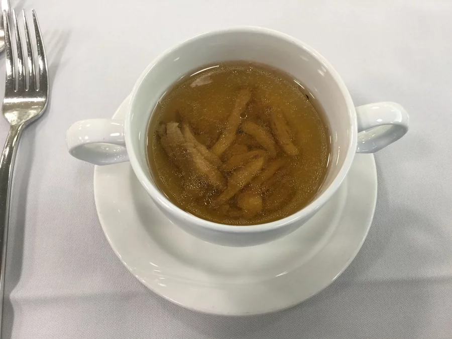 2. Gang: Klare Geflügelkraftbrühe mit Wachtelbrust-Streifen