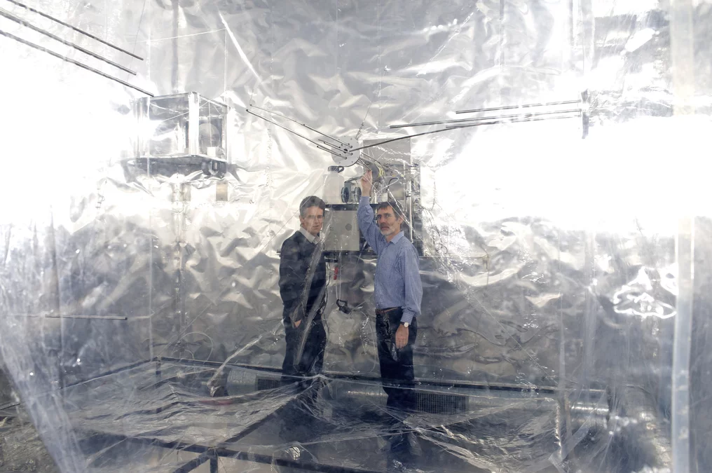 PSI scientists Urs Baltensperger (left) and Josef Dommen next to the smog chamber. (PSI/F. Reiser)