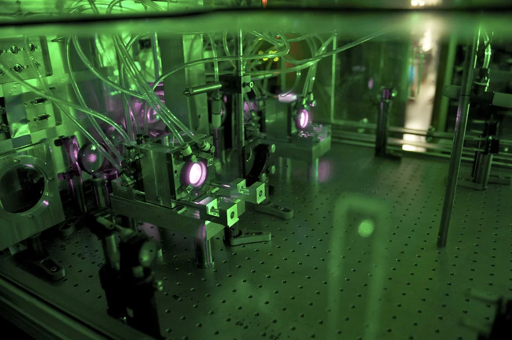 Two water cooled disk laser heads pumped with 1000W (@940 nm) from a fiber coupled diode laser. Each laser head contains an Yb:YAG thin disk (active medium) surrounded by a multipass optical system for the pump radiation.(Photo: PSI/ A. Antognini, F. Reiser)
