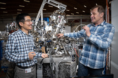 Tianlun Yu (left) and Vladimir Strocov at the ADRESS beamline of the Synchrotron Light Source, where they measured the layered structure made of the semiconductor gallium nitride and the superconductor niobium nitride. (Photo: Paul Scherrer Institute/Mahir Dzambegovic)