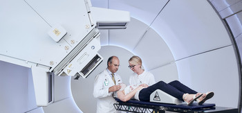 Damien Weber, Head and Chairman of the Center for Proton Therapy at PSI, demonstrates with two colleagues the patient treatment procedure at Gantry 3. 