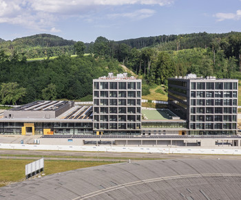Le centre de transfert de technologie Swiss PIC emménagera au Park Innovaare et donc dans le voisinage immédiat du PSI: le toit rond au premier plan de l'image appartient à la Source de Lumière Suisse SLS, qui se trouve sur le site ouest du PSI, derrière lequel on peut voir une partie du complexe de bâtiments du Parc Innovaare.