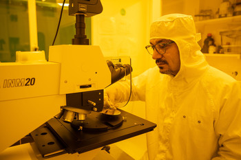 Yasin Ekinci à un microscope dans la salle blanche dans le bâtiment de la SLS 