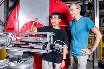 Boyang Zhou (left) and Urs Gasser at one of the experimental stations at PSI, where the complex investigations can be carried out  (Photo: Paul Scherrer Institute/Markus Fischer)