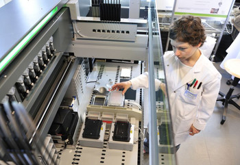Die Strukturbiologin Natacha Olieric neben dem Roboter, an dem am PSI ein automatisiertes Verfahren zur Herstellung von Multiprotein-Komplexen implementiert worden ist.