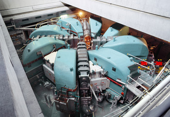 The large PSI Ring Cyclotron accelerates protons to about 80% of the speed of light. The magnets are coloured turquoise and the four acceleration cavities dark grey. (Photo: Paul Scherrer Institute/Markus Fischer)