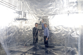 Urs Baltensperger (à gauche) et Josef Dommen, chercheurs au PSI, à côté de la chambre à smog, dans laquelle sont reproduits les processus atmosphériques. (PSI/F. Reiser)