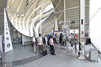 Teilnehmer der Energietagung besichtigen den Sonnenkonzentrator, an dem die Nutzung konzentrierter Solarenergie erforscht wird.