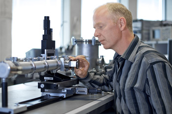 Christian David im Labor. Die Linsen werden in die metallische Testkammer eingebaut, das einem Teil der zukünftigen SwissFEL-Optik entspricht. (Foto: PSI/M. Fischer)