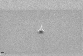 Der von einer diamantenen Zonenplatte fokussierte Röntgenlaserpuls erzeugt Krater in einer Metalloberfläche. Bei tausendfacher Abschwächung: Krater mit 200 Nanometer Durchmesser (REM-Aufnahme)