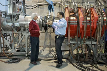 Experiment zum Myonenzerfall: die PSI-Forscher Peter-Raymond Kettle (links) und Stefan Ritt vor dem Strahlrohr, durch das die Myonen zum Experiment geleitet werden. (Paul Scherrer Institut/M. Fischer)
