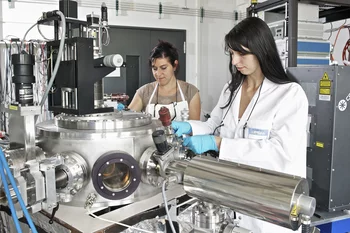 The researchers Claudia Cancellieri (left) and Mathilde Reinle-Schmitt at an apparatus that produces thin layers of different materials with the aid of a laser (Paul Scherrer Institute/M. Fischer)