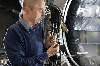 Experiment zum Myoneinfang: Der PSI-Forscher Malte Hildebrandt arbeitet am Detektor, mit dem der Myonenenfang am Proton gemessen wird. (Foto: Paul Scherrer Institut/Markus Fischer)