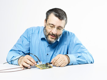 For the experiment on rare muon decays, physicist Stefan Ritt developed the DRS4 microchip which can measure time intervals of billionths of a second and replaces a large and expensive oscilloscope. The chip itself is located underneath the black square on the circuit board. (Photo: Scanderbeg Sauer Photography)