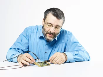 For the experiment on rare muon decays, physicist Stefan Ritt developed the DRS4 microchip which can measure time intervals of billionths of a second and replaces a large and expensive oscilloscope. The chip itself is located underneath the black square on the circuit board. (Photo: Scanderbeg Sauer Photography)