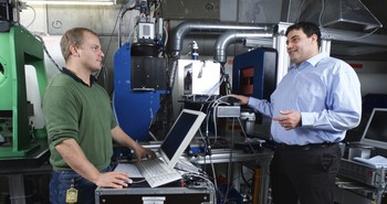 PSI-researchers Benedikt Betz and Christian Grünzweig at the neutron instrument, which allows them to explore the magnetic processes taking place within a transformer’s iron core. (Photo: Paul Scherrer Institute/Markus Fischer)
