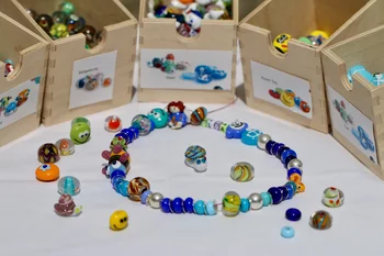 Jedes Kind bekommt während der Zeit seiner Protonentherapie zur Belohnung eine Perlenkette mit seinem Namen. Diese zeigt die Geschichte seiner Behandlung. Denn für jede Bestrahlung und jede Untersuchung gibt es eine neue handgefertigte Glasperle. (Foto: Paul Scherrer Institut/Manuela Reisinger)