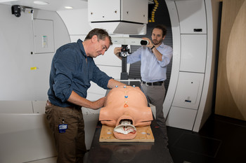 The medical physicists Antony Lomax and Giovanni Fattori examine the phantom Luca, evaluating procedures for the optimum irradiation of moving tumours with protons. Luca is based on the form of a human torso. Breathing movements are simulated with the help of a pump. Its interior is full of measuring devices and markers are attached to its surface, enabling researchers to monitor breathing movements during a radiation session via video camera. (Photo: Paul Scherrer Institute/Mahir Dzambegovic)