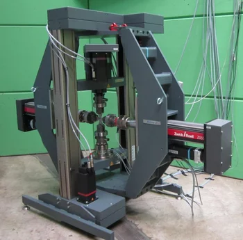 Image of the POLDI multi-axial test rig (Zwick Roell) with a cruciform-shaped specimen mounted at the centre of the rig.