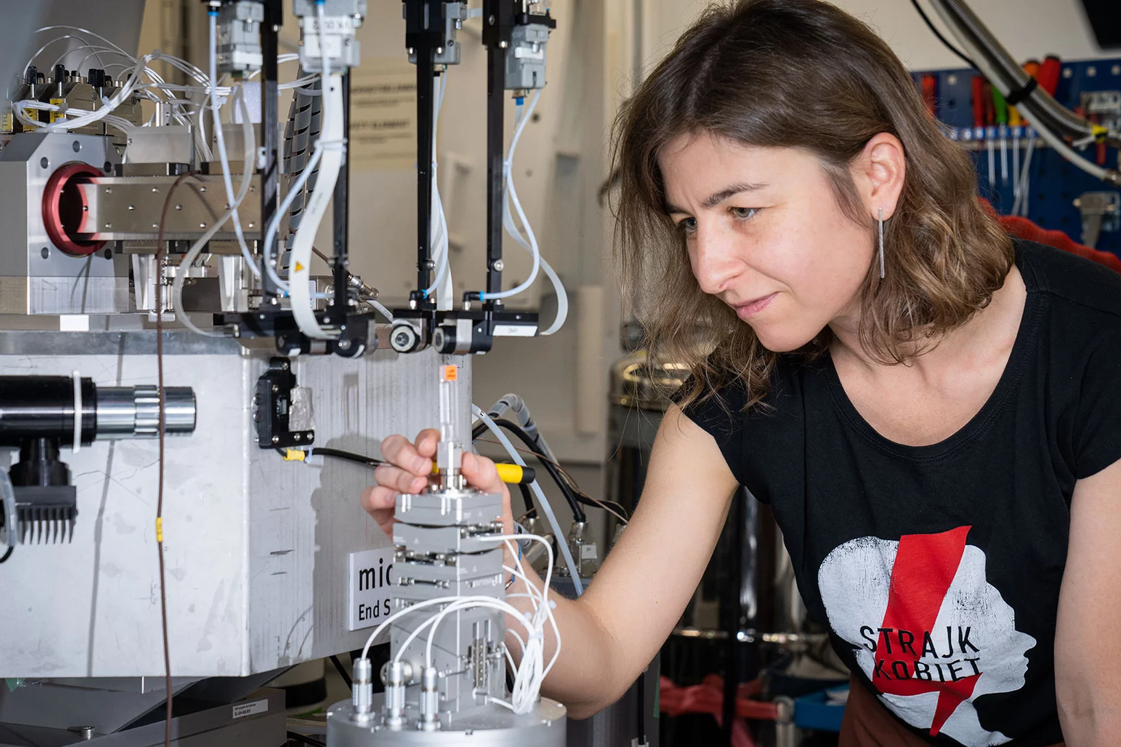 Malgorzata Makowska, scientist at the MicroXAS beamline of the SLS, carefully positions a standard material for setup calibration on the sample manipulator in front of the X-ray beam.  