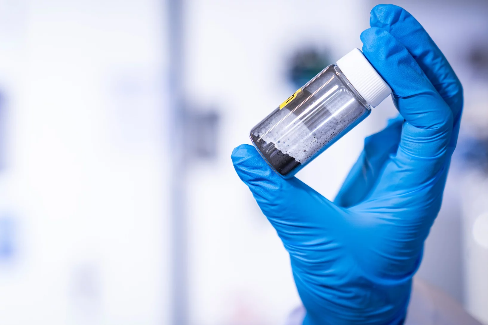 Im Fokus: ein Glasfläschchen mit Katalysatorpulver auf Kobaltbasis – aufgenommen im Labor des Paul Scherrer Instituts PSI. Forschende des Zentrums für Energie- und Umweltwissenschaften haben gezeigt, warum dieser Katalysator bei der Herstellung von Wasserstoff im alkalischen Milieu besonders effizient wirkt. 