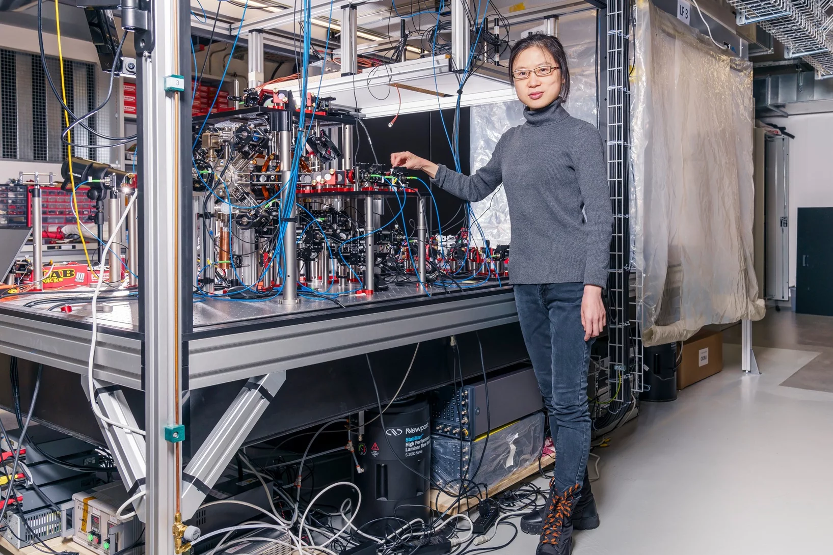 Wenchao Xu by the Quantum Engineering group’s experimental setup, which uses neutral, individual atoms as building blocks for quantum computers.
