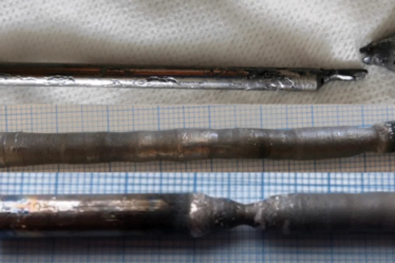 Photos of (a) the cast CeAlGe rod, and the floating-zone-grown crystals of (b) CeAlGe and (c) PrAlGe.