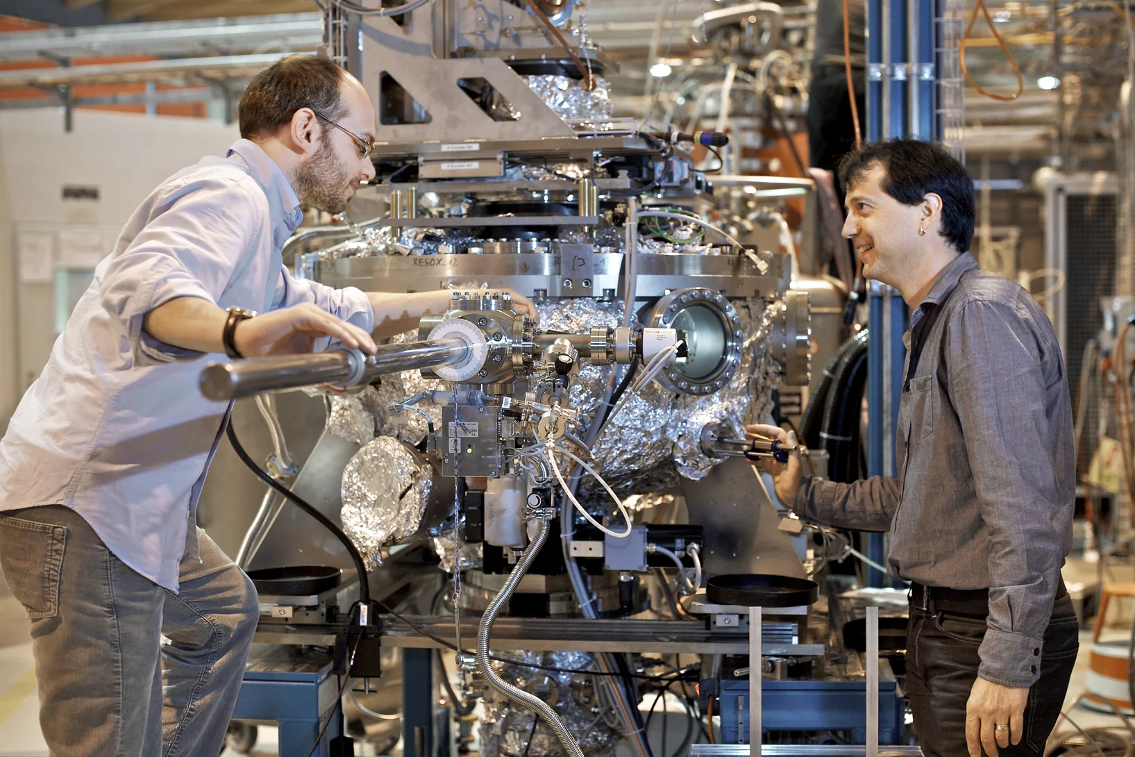 PSI scientists Valerio Scagnoli (left) and Urs Staub working on their experiment at SLS